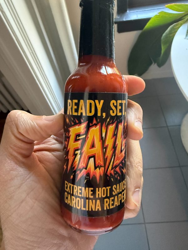 The delivered Ready, Set, Fail hot sauce bottle, held in hand